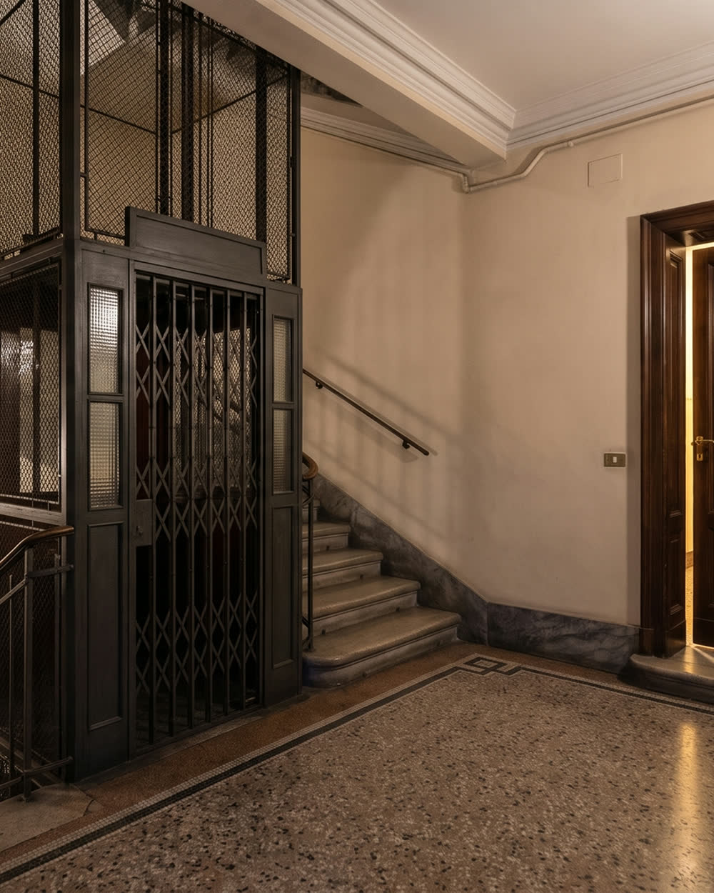 Pianerottolo di un palazzo milanese, con la porta di un appartamento.